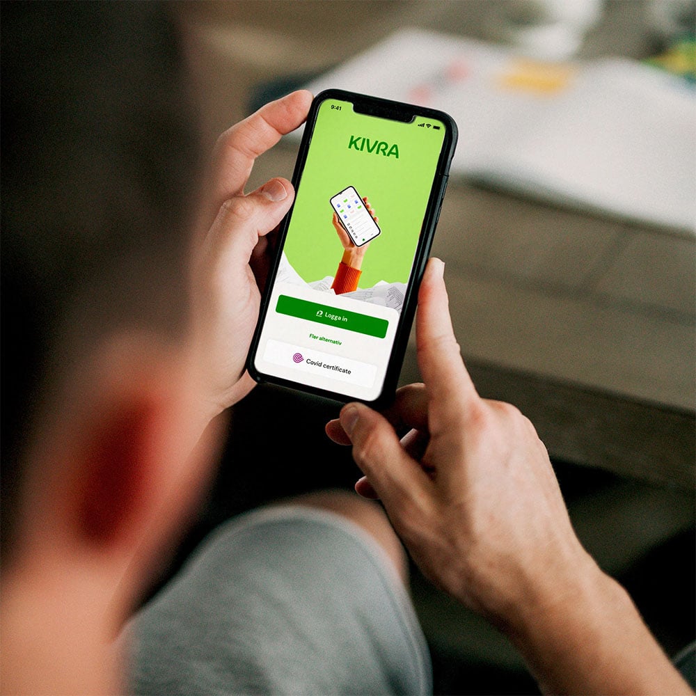 Man holding a phone with Kivra. 