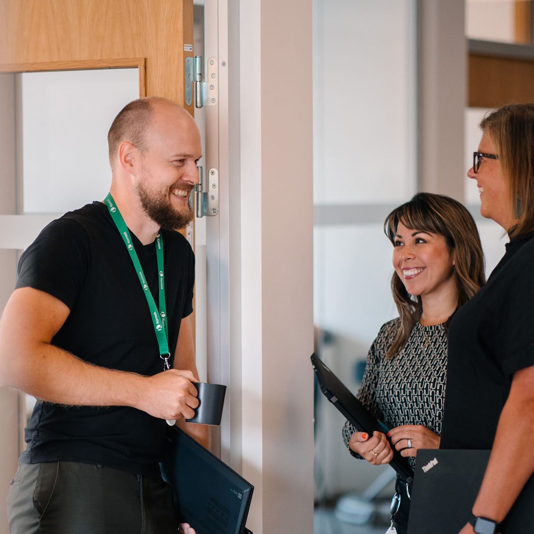 a man is standing and talking to two women
