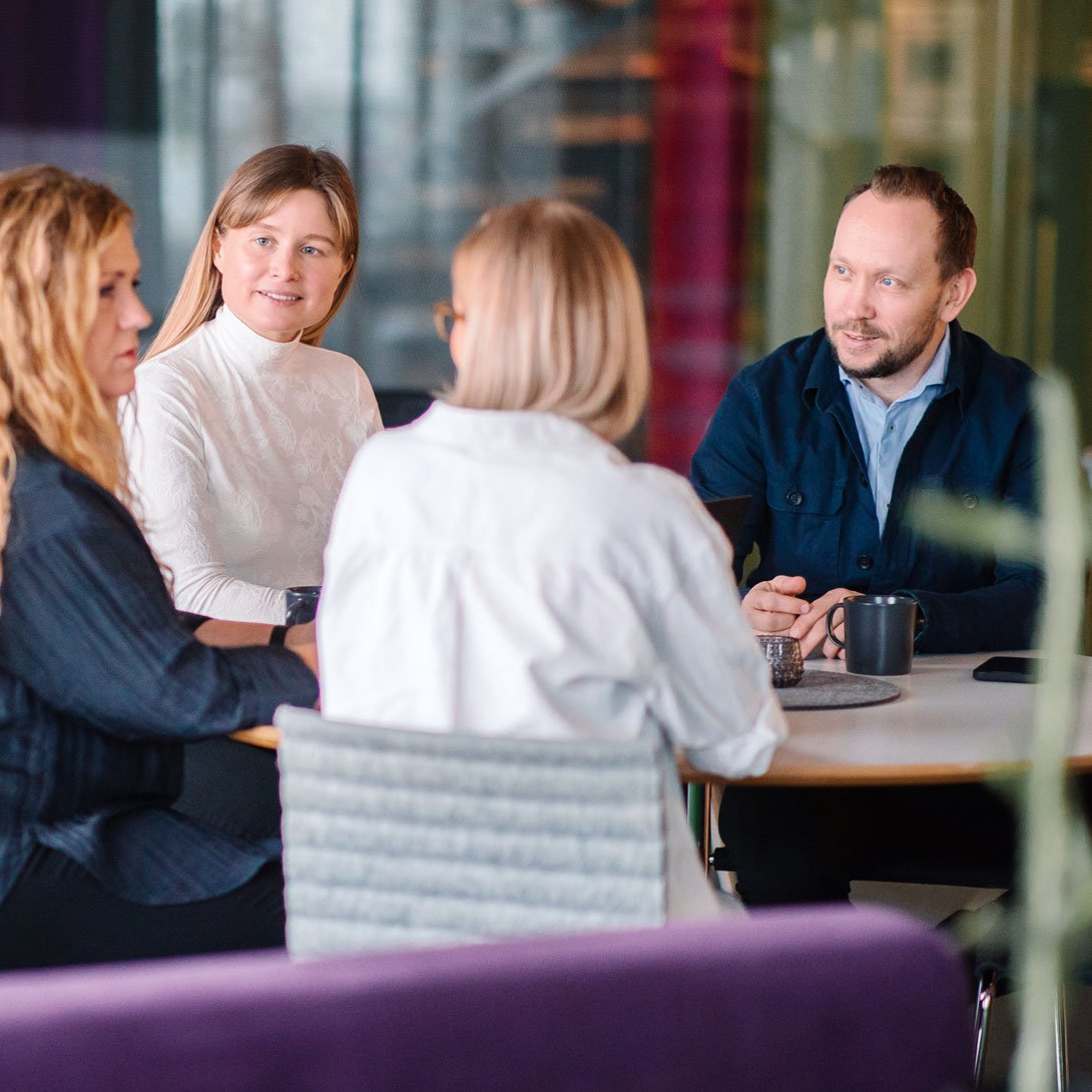 grupp som sitter vid ett bord och pratar