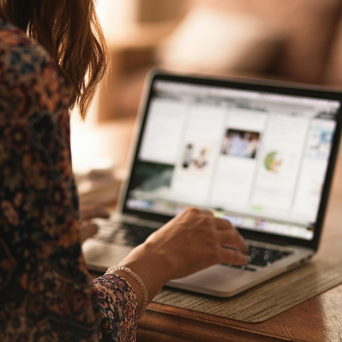Woman sitting at a laptop and typing