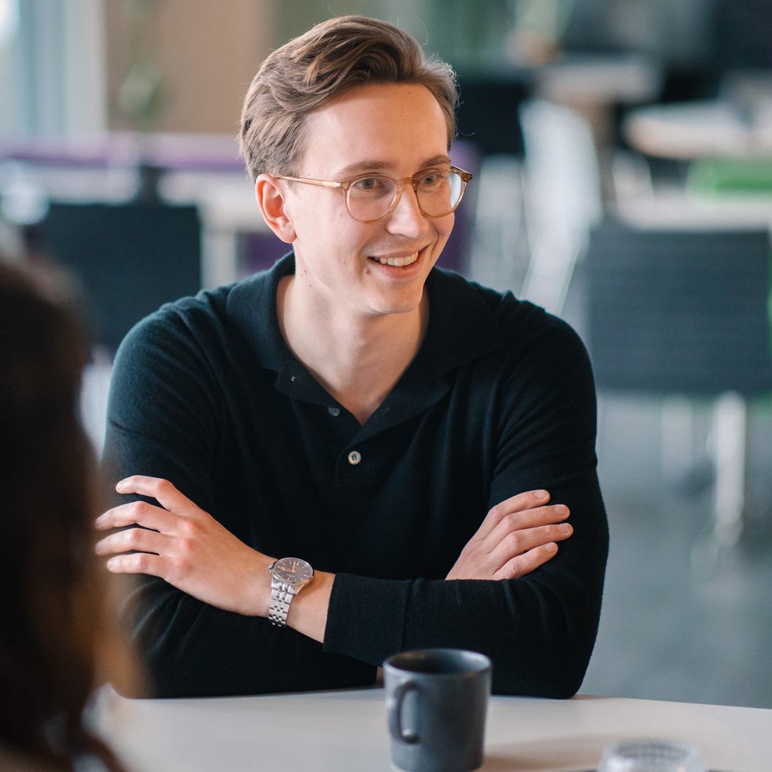 man with glasses drinking coffee.